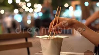 亚洲食品的纸板箱和手拿筷子。